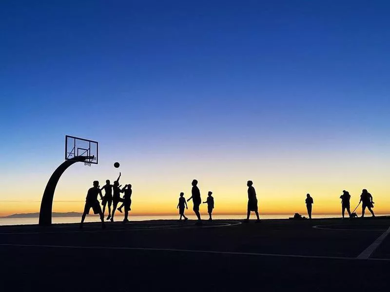 People playing Angels Gate Park Basketball Court at sunset