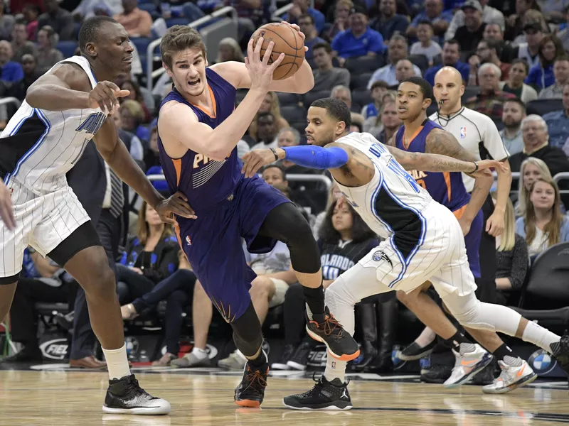 Phoenix Suns forward Dragan Bender drives between Orlando Magic center Bismack Biyombo and guard D.J. Augustin