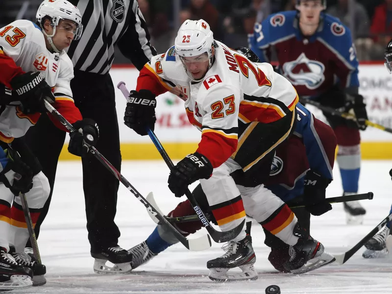 Sean Monahan reaches out for loose puck