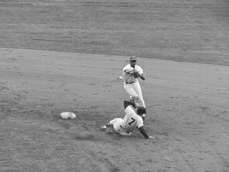 Chicago Cubs shortstop Ernie Banks leaps off ground and throws