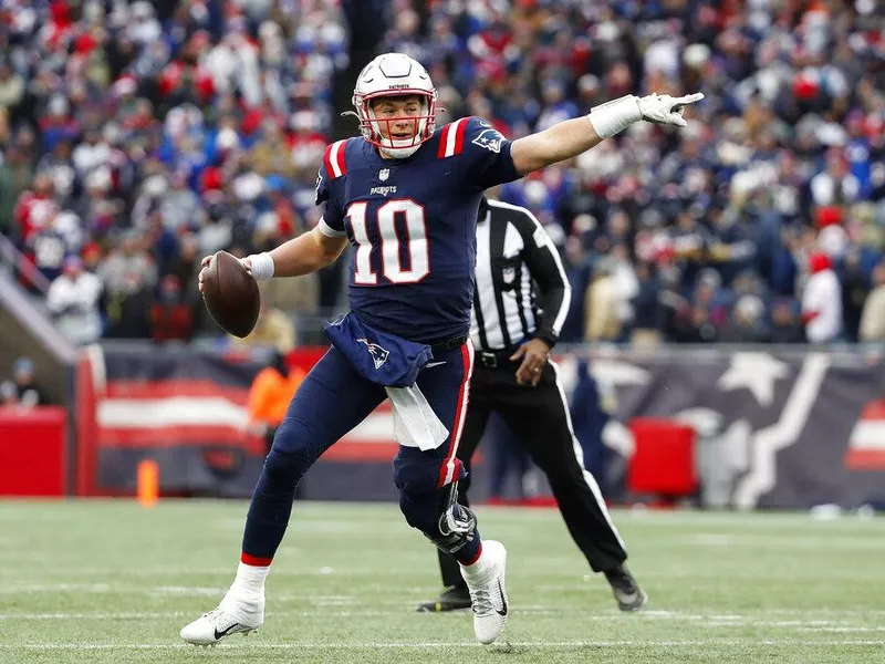 New England Patriots quarterback Mac Jones points on the field