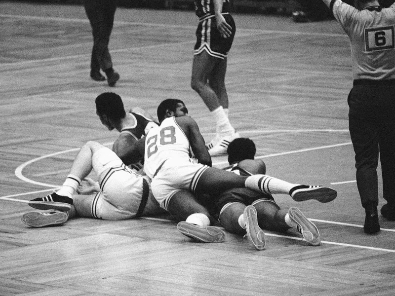 Boston Celtics Jim Barnes lands on top of teammate Larry Siegfried, and Cincinnati Royals Bill Turner and Johnny Green