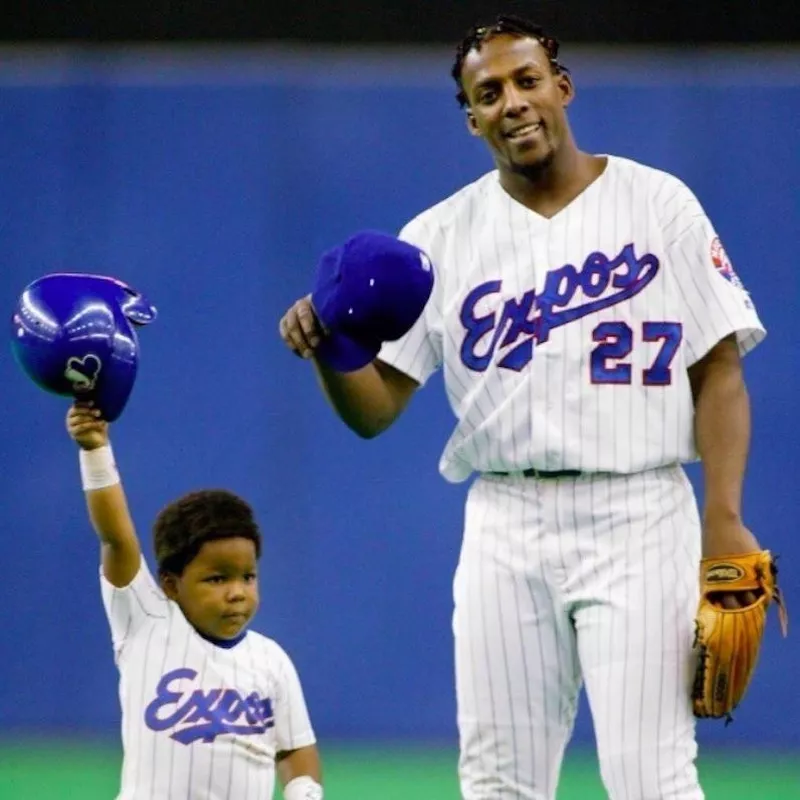 Vladimir Guerrero Jr and his father Vladimir Guerrero hold up hats in 2002