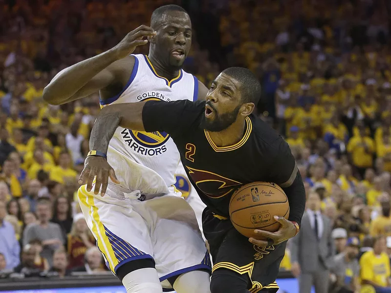 Kyrie Irving drives against Golden State Warriors forward Draymond Green