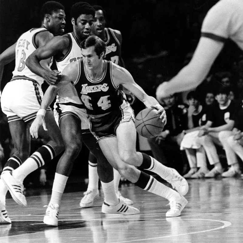 Jerry West drives around Milwaukee Bucks guard Oscar Robertson and Curtis Perry