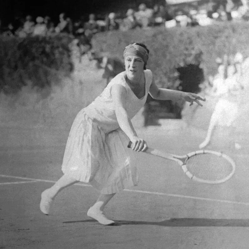 Female tennis champion Suzanne Lenglen strikes a backhand