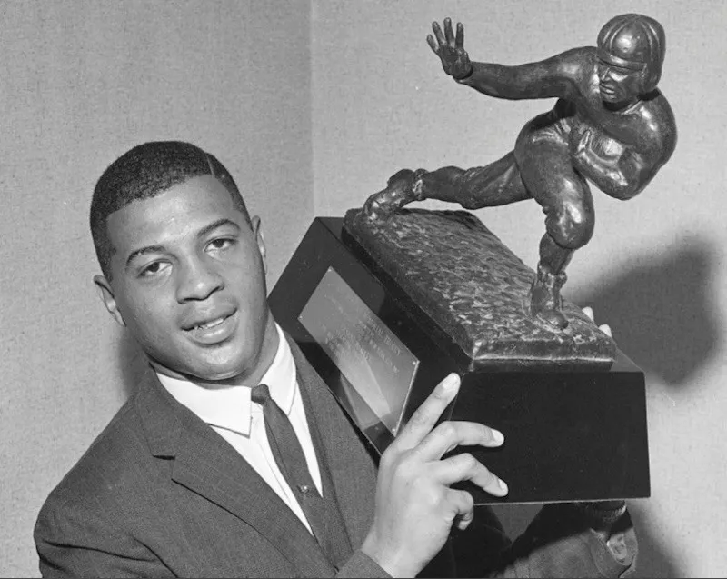 Ernie Davis holding up Heisman Trophy