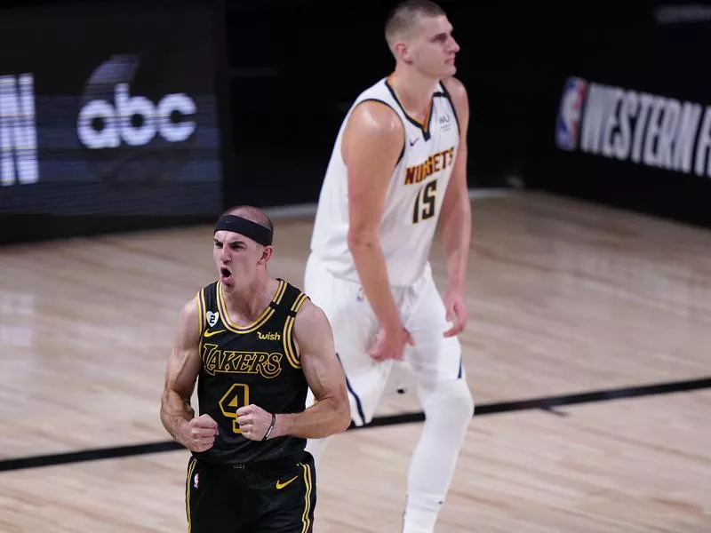 Alex Caruso celebrates in front of Denver Nuggets' Nikola Jokic