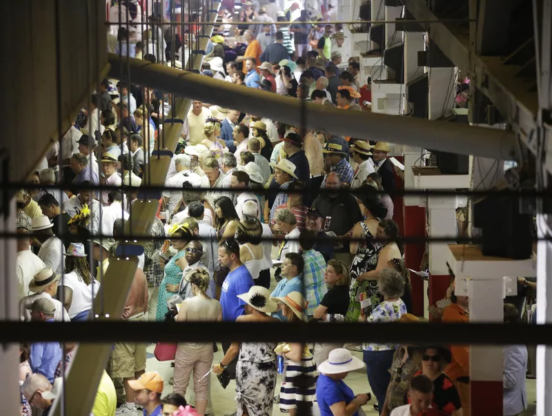 Racing fans in betting lines at the Preakness Stakes at Pimlico