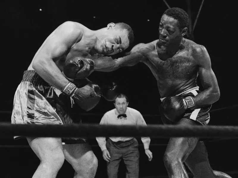 Ezzard Charles delivers hard right to midsection of Joe Louis