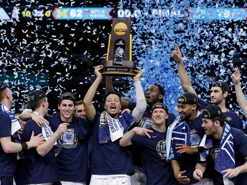 Villanova players celebrate with the trophy after beating Michigan