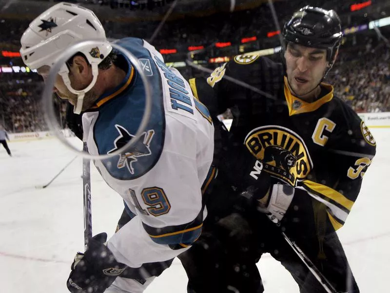 Zdeno Chara pressures Joe Thornton against boards