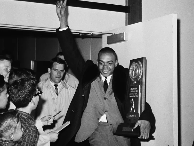 UCLA's Walt Hazzard carries NCAA trophy